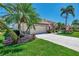 House with lush landscaping and palm trees in front at 2878 Egret Ct, North Port, FL 34287
