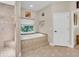 Modern bathroom featuring a walk-in shower, soaking tub, and neutral tile flooring at 3200 Rowland Dr, Punta Gorda, FL 33980