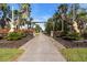 Paved driveway entrance to Tall Palms Ranch, featuring horse statues and tropical landscaping at 3200 Rowland Dr, Punta Gorda, FL 33980