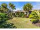 Exterior view of house amidst tropical foliage and lawn at 3200 Rowland Dr, Punta Gorda, FL 33980