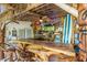 Tiki-style outdoor bar with a wooden countertop, thatched roof, and unique decor at 3200 Rowland Dr, Punta Gorda, FL 33980