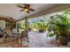 Covered patio with seating and views of the screened-in pool and lush landscaping at 3200 Rowland Dr, Punta Gorda, FL 33980