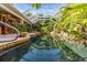Inviting pool area with lush greenery, waterfall, and a screened enclosure for year-round enjoyment at 3200 Rowland Dr, Punta Gorda, FL 33980