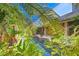 Tranquil backyard oasis featuring a pool surrounded by lush tropical landscaping at 3200 Rowland Dr, Punta Gorda, FL 33980