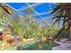 Enclosed pool area with lush landscaping, waterfall feature, and ample natural light at 3200 Rowland Dr, Punta Gorda, FL 33980