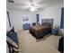 Well-lit bedroom featuring a patterned bedspread, blue accents, and carpeted floor at 3978 Weidman Ave, North Port, FL 34286