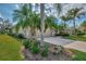 Two-car garage with landscaping and palm trees at 3984 Whispering Oaks Dr, North Port, FL 34287