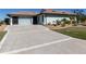 Large concrete driveway with decorative lines leading to the garage at 4301 Oak Terrace Cir, Port Charlotte, FL 33953