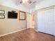 Bedroom with wood-look tile floors, double door closet and wall mounted TV at 5255 Athens Way, Venice, FL 34293