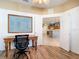 Home office with view into kitchen, hardwood floors, and built-in shelving at 5255 Athens Way, Venice, FL 34293