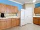 Bright kitchen with oak cabinets, white appliances, and tile backsplash at 5255 Athens Way, Venice, FL 34293