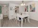 Bright dining area with white furniture and beach-themed decor at 533 Parkdale Mews # 533, Venice, FL 34285