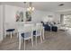 Dining area adjacent to living room, featuring white table and blue chairs at 533 Parkdale Mews # 533, Venice, FL 34285