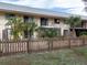 Exterior view of a condo building with balconies, palm trees, and a wooden fence at 533 Parkdale Mews # 533, Venice, FL 34285