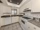 Compact kitchen with white appliances, dark countertops, and ample storage at 533 Parkdale Mews # 533, Venice, FL 34285