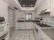Well-equipped kitchen with white cabinets, dark granite counters, and white appliances at 533 Parkdale Mews # 533, Venice, FL 34285