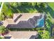 Aerial view of tile roof, screened pool, landscaping, and palm trees, showcasing the home's luxurious outdoor space at 5584 Cantucci St, Nokomis, FL 34275
