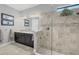 Well-lit bathroom featuring a glass-enclosed shower, double vanity and attractive tile at 5584 Cantucci St, Nokomis, FL 34275