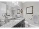 Well-lit bathroom featuring granite counters, dark wood cabinets, and tiled shower at 5584 Cantucci St, Nokomis, FL 34275
