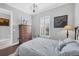 Cozy bedroom with wood floors, plantation shutters, and a decorative chandelier at 5584 Cantucci St, Nokomis, FL 34275