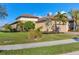 Exterior view of a home with a clay tile roof, landscaped front yard, and a welcoming driveway at 5584 Cantucci St, Nokomis, FL 34275