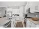 Bright kitchen featuring white cabinetry, stainless steel appliances, and a granite countertop island with barstool seating at 5584 Cantucci St, Nokomis, FL 34275