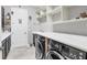 Laundry room with front-load washer and dryer, built in shelving, and plenty of counter space at 5584 Cantucci St, Nokomis, FL 34275