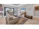 Cozy living room features neutral tones, tile flooring, and sliding doors to a screened-in lanai at 5584 Cantucci St, Nokomis, FL 34275