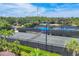 Scenic view of community tennis courts with lush landscaping, palms trees and blue skies above at 5584 Cantucci St, Nokomis, FL 34275