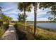 Paved walking path alongside tranquil lake with lush green foliage and neighborhood homes in the background at 5584 Cantucci St, Nokomis, FL 34275