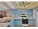 Bright kitchen with light blue cabinets and modern appliances at 629 Alhambra Rd # 704, Venice, FL 34285