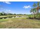 Lush green golf course with a pond and palm trees at 676 Eagle Watch Ln, Osprey, FL 34229