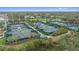 Multiple tennis courts surrounded by green areas and palm trees, aerial view at 676 Eagle Watch Ln, Osprey, FL 34229