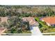 An aerial view featuring a home with a tile roof, lush landscaping, and a well-manicured lawn at 6930 Treymore Ct, Sarasota, FL 34243