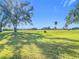 Scenic view of a lush green golf course with mature trees under a clear sky at 758 Village Cir # 106, Venice, FL 34292