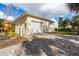 Detached garage with a paved driveway and mature landscaping providing great curb appeal at 7825 Manasota Key Rd, Englewood, FL 34223