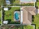 An aerial view of a home with a kidney-shaped pool, fenced yard, and storage sheds at 832 Pineland Ave, Venice, FL 34285