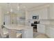 Bright kitchen featuring an island with bar stool seating, pendant lighting, and stainless appliances at 10039 Crooked Creek Dr # 203, Venice, FL 34293