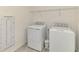 Functional laundry room with washer, dryer, and wall-mounted ironing board at 10039 Crooked Creek Dr # 203, Venice, FL 34293