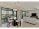Open-concept design seamlessly connects living and dining spaces with balcony access at 10039 Crooked Creek Dr # 203, Venice, FL 34293