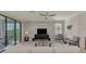 Bright living room featuring a ceiling fan, large windows and sliding door to balcony at 10039 Crooked Creek Dr # 203, Venice, FL 34293