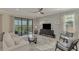 A bright living room featuring modern furniture, stylish decor, and a scenic balcony view at 10039 Crooked Creek Dr # 203, Venice, FL 34293