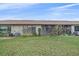 Exterior view of the home from the backyard features a grassy lawn and lush landscaping at 1211 Capri Isles Blvd # 58, Venice, FL 34292