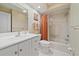 Clean and bright bathroom with white fixtures, tiled shower, and orange striped curtain at 1211 Capri Isles Blvd # 58, Venice, FL 34292