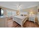 Spacious main bedroom with a king-size bed, wood floors, and a ceiling fan at 1211 Capri Isles Blvd # 58, Venice, FL 34292