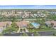 Aerial view showcasing the community pool surrounded by lush landscaping, homes, and parking at 1211 Capri Isles Blvd # 58, Venice, FL 34292