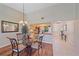 Dining area with glass-top table, decorative chandelier, and views into the kitchen at 1211 Capri Isles Blvd # 58, Venice, FL 34292