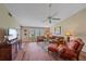 Living room with comfy seating, ceiling fan, wood floors, and sliding glass doors at 1211 Capri Isles Blvd # 58, Venice, FL 34292