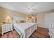 Main bedroom with ensuite access, white furniture, and wood-look floors at 1211 Capri Isles Blvd # 58, Venice, FL 34292
