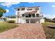 Charming two-story home with a tiled roof, white exterior, and brick driveway at 130 Green Dolphin Dr, Placida, FL 33946